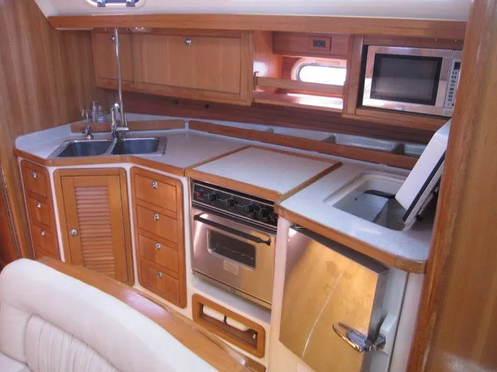  Yacht Photos Pics 2007 Catalina MkII yacht kitchen with wood cabinetry, stainless steel appliances, and double sink.