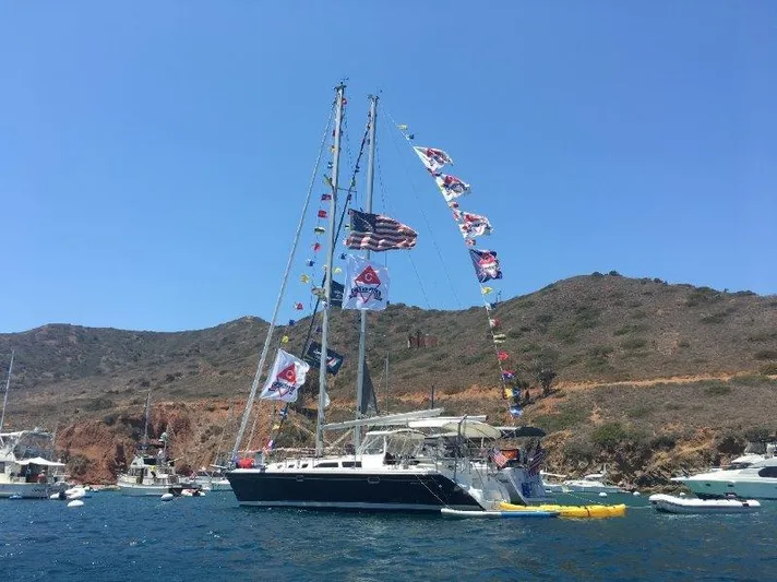  Yacht Photos Pics 2007 Catalina MkII sailboat with flags anchored near rocky coastline.