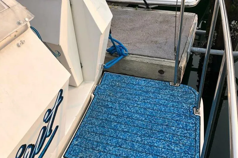  Yacht Photos Pics 1985 Bayliner 4550 Motoryacht docked with blue deck mat and mooring lines.