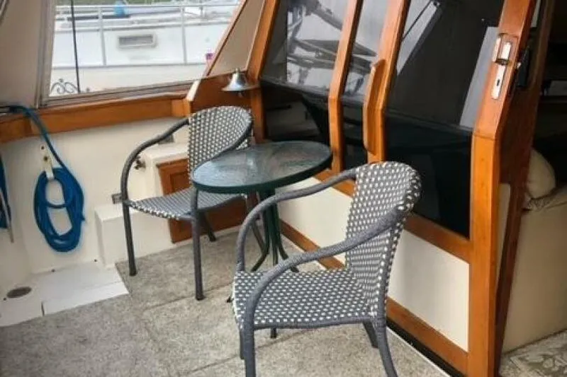  Yacht Photos Pics 1985 Bayliner 4550 Motoryacht deck with chairs and table, featuring wood accents.