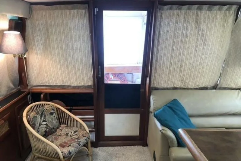  Yacht Photos Pics Interior of 1985 Bayliner 4550 Motoryacht with wicker chair, sofa, and curtains.