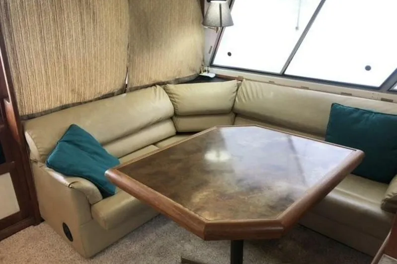  Yacht Photos Pics Interior of 1985 Bayliner 4550 Motoryacht with beige seating and wooden table.