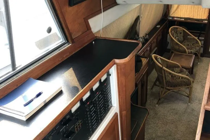  Yacht Photos Pics Interior of 1985 Bayliner 4550 Motoryacht with wood paneling and wicker chairs.