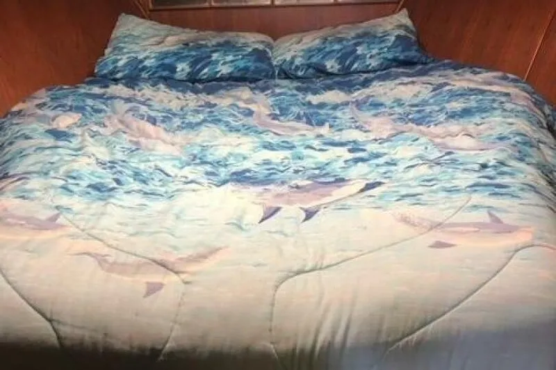  Yacht Photos Pics Bed with ocean-themed bedding inside a 1985 Bayliner 4550 Motoryacht cabin.