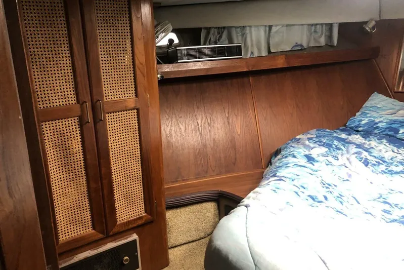  Yacht Photos Pics Cozy cabin interior of 1985 Bayliner 4550 Motoryacht with wood paneling and blue bedding.