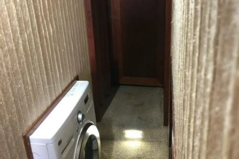  Yacht Photos Pics Narrow hallway in 1985 Bayliner 4550 Motoryacht with washing machine and wooden door.