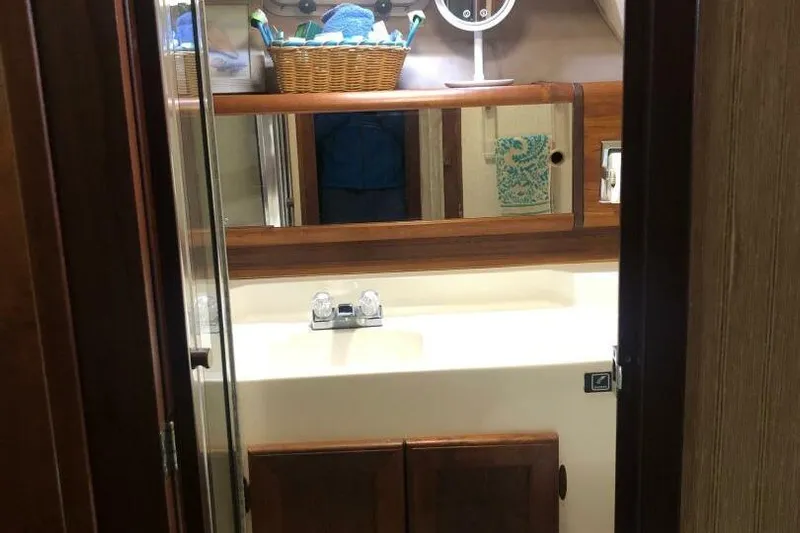  Yacht Photos Pics Bathroom interior of 1985 Bayliner 4550 Motoryacht with wooden cabinets and mirror.
