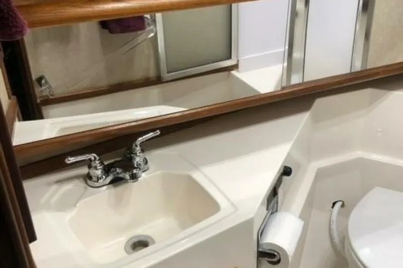  Yacht Photos Pics Bathroom interior of 1985 Bayliner 4550 Motoryacht with sink, mirror, and toilet.