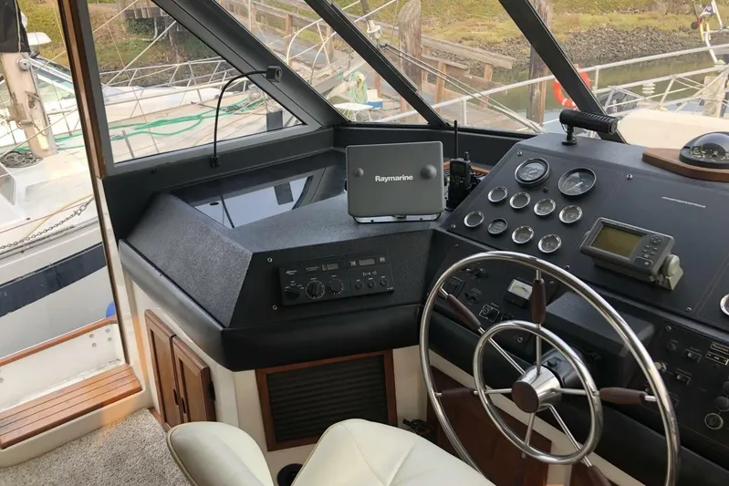  Yacht Photos Pics Interior helm of 1985 Bayliner 4550 Motoryacht with steering wheel and navigation equipment.