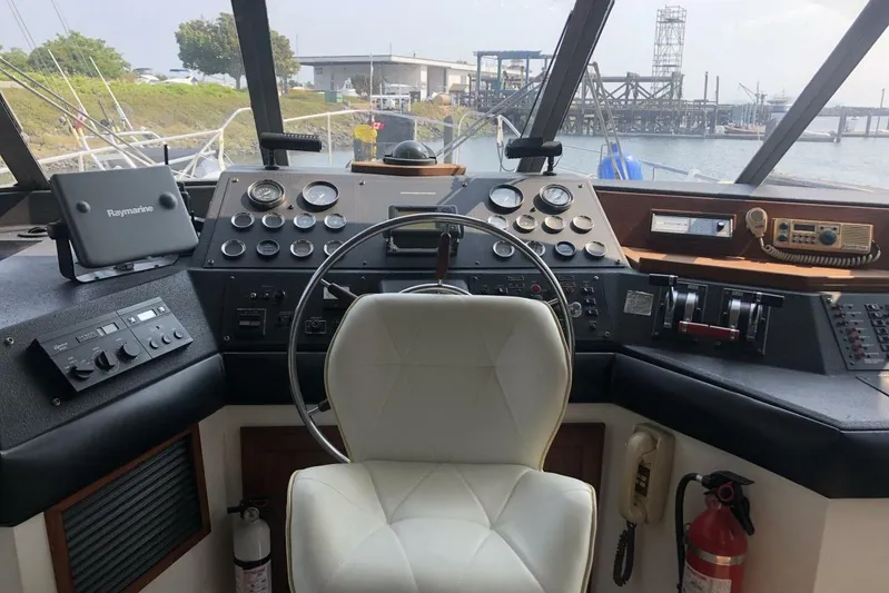  Yacht Photos Pics 1985 Bayliner 4550 Motoryacht helm with steering wheel, gauges, and navigation equipment.