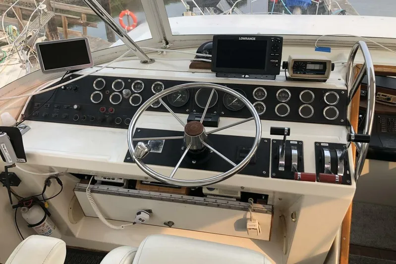  Yacht Photos Pics 1985 Bayliner 4550 Motoryacht helm with steering wheel, gauges, and navigation equipment.