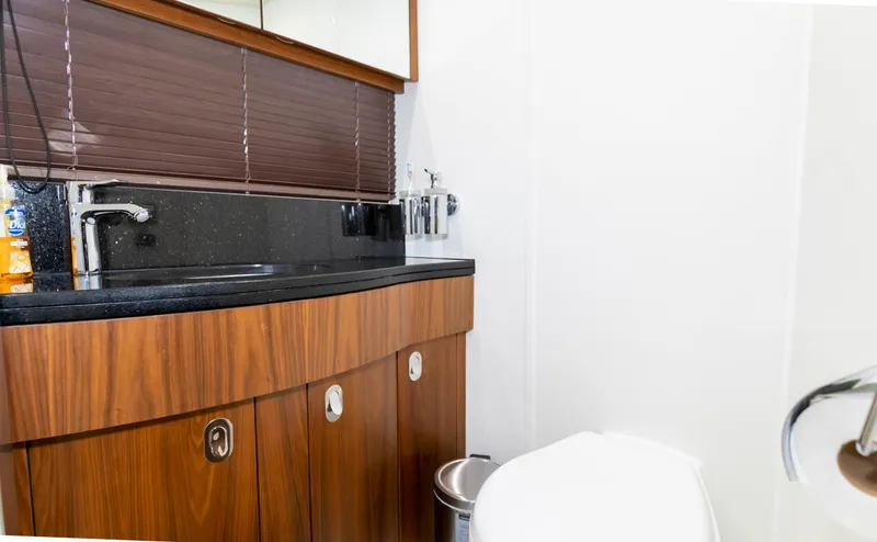 Ohana Yacht Photos Pics Luxurious bathroom in 2016 Sunseeker Manhattan 55 yacht with wooden cabinetry and modern fixtures.