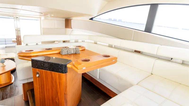 Ohana Yacht Photos Pics Luxurious interior of 2016 Sunseeker Manhattan 55 yacht with elegant seating and wooden table.