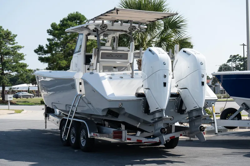  Yacht Photos Pics 2025 Solace 32 CS boat on trailer with dual outboard engines, parked outdoors.