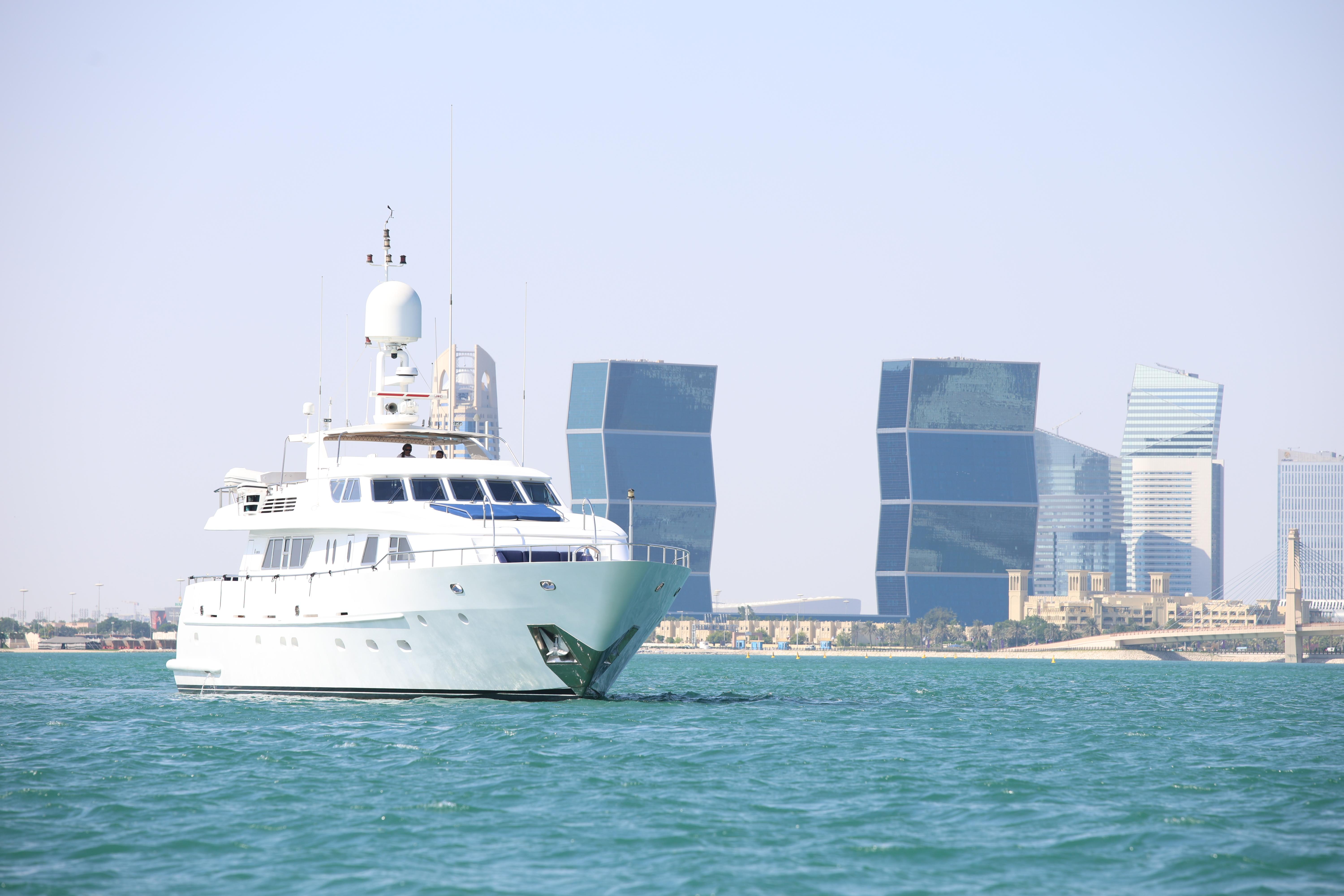 Luxurious 1999 Codecasa 105 Custom yacht sailing near modern city skyline.