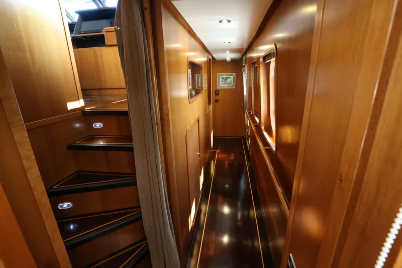  Yacht Photos Pics Luxurious wooden interior of 1999 Codecasa 105 Custom yacht, featuring elegant hallway and staircase.