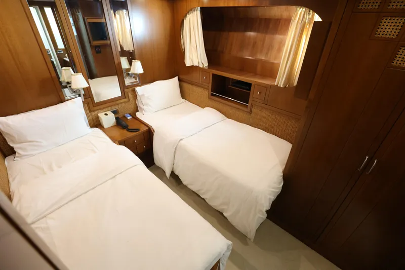  Yacht Photos Pics Luxurious twin cabin interior on 1999 Codecasa 105 Custom yacht, featuring wooden decor and cozy beds.