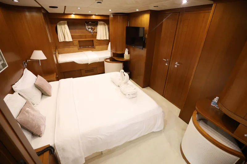  Yacht Photos Pics Luxurious bedroom interior of 1999 Codecasa 105 Custom yacht with wooden decor and cozy bedding.