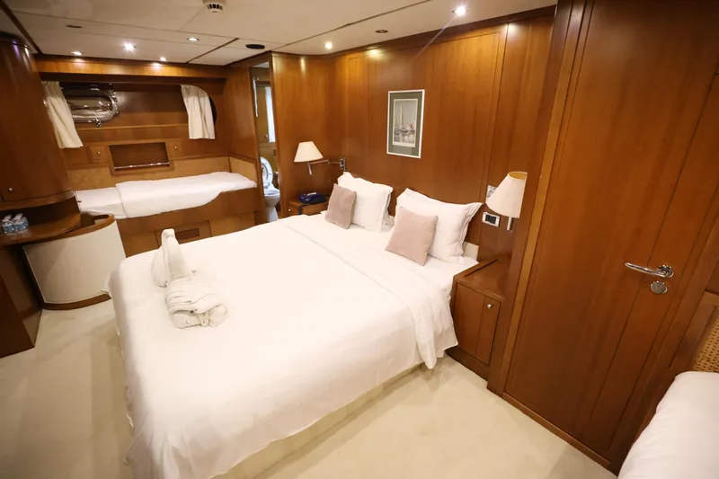  Yacht Photos Pics Luxurious bedroom interior on 1999 Codecasa 105 Custom yacht with wooden paneling and elegant bedding.