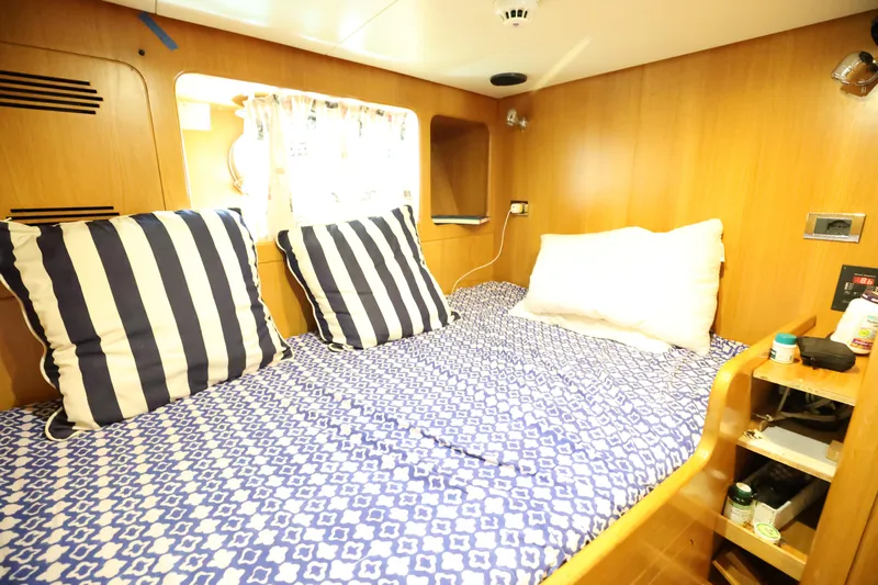  Yacht Photos Pics Cozy cabin interior of 1999 Codecasa 105 Custom yacht with striped pillows and patterned bedding.