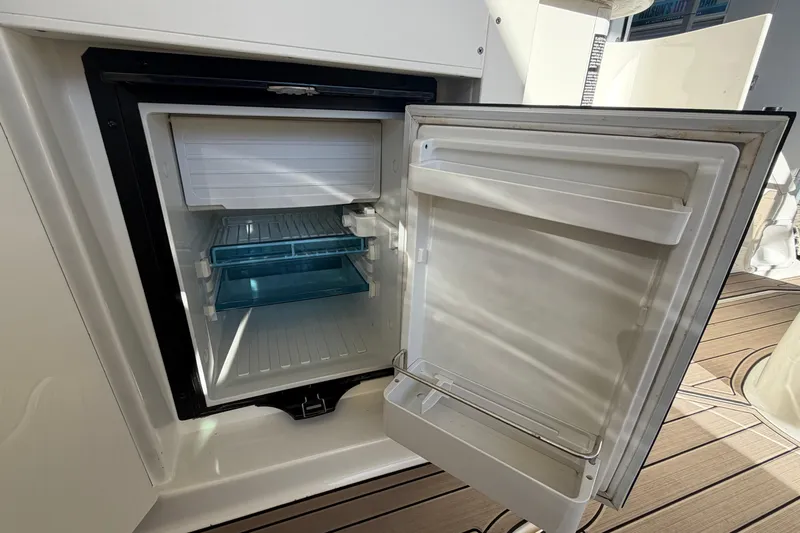  Yacht Photos Pics Open refrigerator on 2014 Sea Ray 370 Sundancer yacht, showcasing interior shelves.