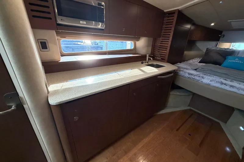  Yacht Photos Pics Luxurious interior of 2014 Sea Ray 370 Sundancer with kitchenette and cozy sleeping area.