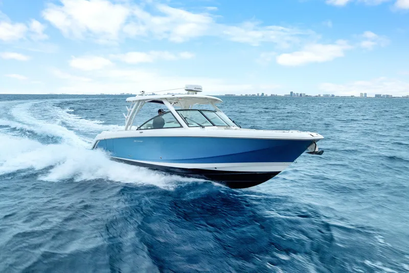  Yacht Photos Pics 2018 Boston Whaler 320 Vantage cruising on open water under a clear blue sky.