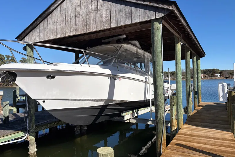 In Absentia Yacht Photos Pics 2017 Everglades 350LX boat docked under wooden shelter by the water.