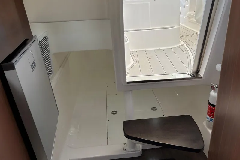 In Absentia Yacht Photos Pics 2017 Everglades 350LX interior with fridge, seating, and fire extinguisher.