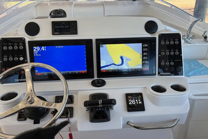 In Absentia Yacht Photos Pics Control panel of a 2017 Everglades 350LX boat with navigation screens and steering wheel.