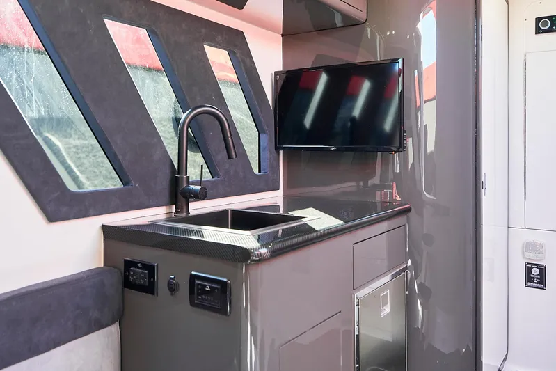  Yacht Photos Pics Interior of 2021 Midnight Express 43' Solstice yacht with sleek kitchenette and modern TV.