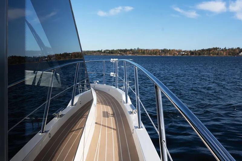  Yacht Photos Pics 2024 Galeon 440 Fly yacht cruising on a serene lake with clear blue skies.