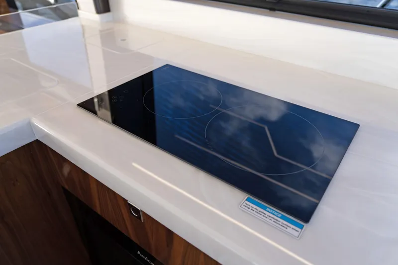  Yacht Photos Pics Modern kitchen cooktop on 2024 Galeon 440 Fly yacht, featuring sleek design and reflective surface.