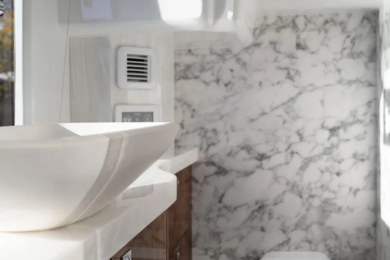  Yacht Photos Pics Luxurious bathroom in 2024 Galeon 440 Fly yacht with marble walls and modern sink.