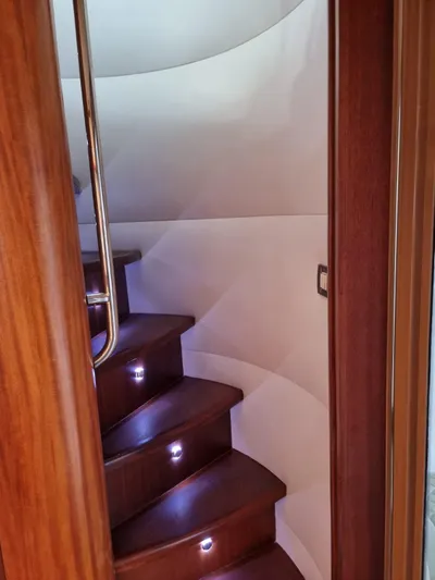  Yacht Photos Pics Interior staircase of 2009 Bertram 700 Enclosed yacht with wooden steps and LED lighting.