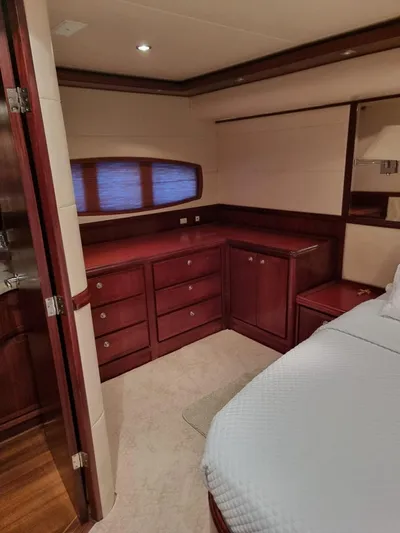  Yacht Photos Pics 2009 Bertram 700 Enclosed yacht bedroom with wooden cabinetry and cozy lighting.