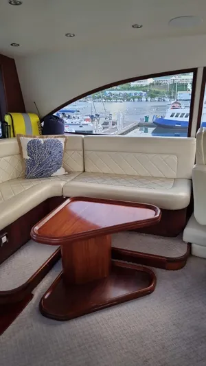  Yacht Photos Pics Interior of a 2009 Bertram 700 Enclosed yacht with leather seating and wooden table.