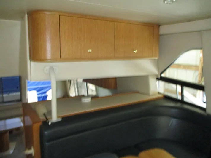 Spice Yacht Photos Pics Interior of 2000 Bayliner 5288 Pilot House with wood cabinets and black seating.