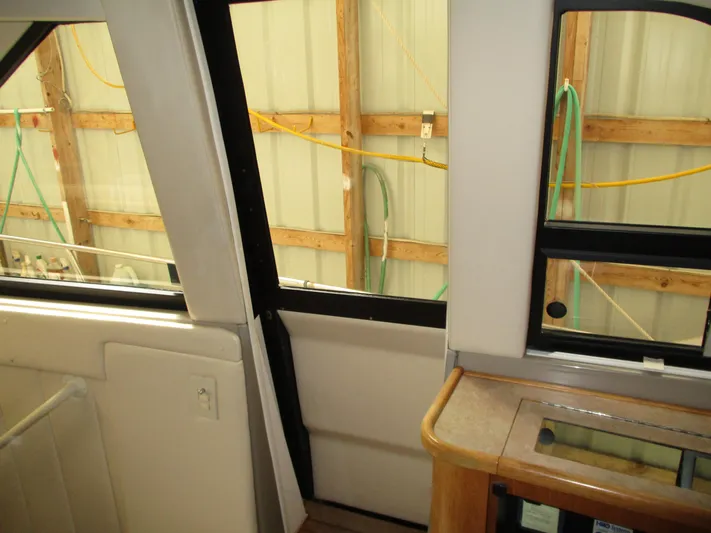 Spice Yacht Photos Pics Interior view of 2000 Bayliner 5288 Pilot House with wooden accents and large windows.