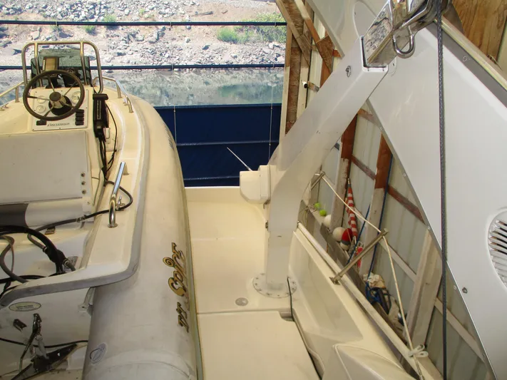 Spice Yacht Photos Pics Bayliner 5288 Pilot House 2000 with inflatable boat on deck, docked in a covered marina.