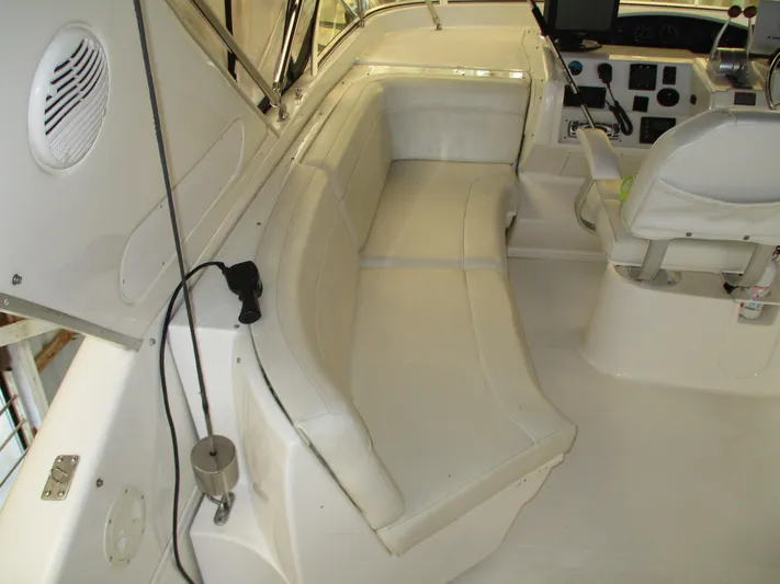 Spice Yacht Photos Pics Interior of 2000 Bayliner 5288 Pilot House with white seating and control panel.