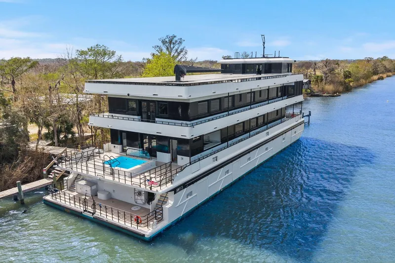 Shine Down Yacht Photos Pics Luxurious 2025 Breaux Brothers 120 GLV yacht with pool, docked on a serene river.