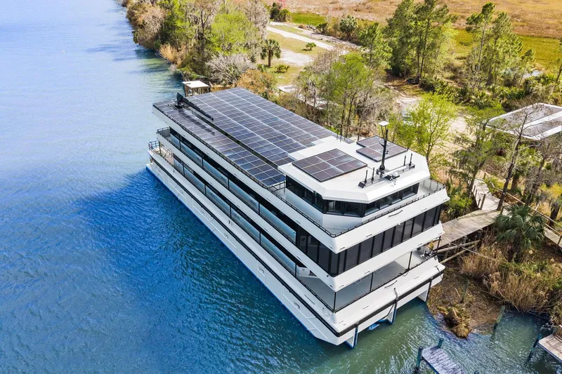Shine Down Yacht Photos Pics Aerial view of 2025 Breaux Brothers 120 GLV yacht with solar panels on a serene river.
