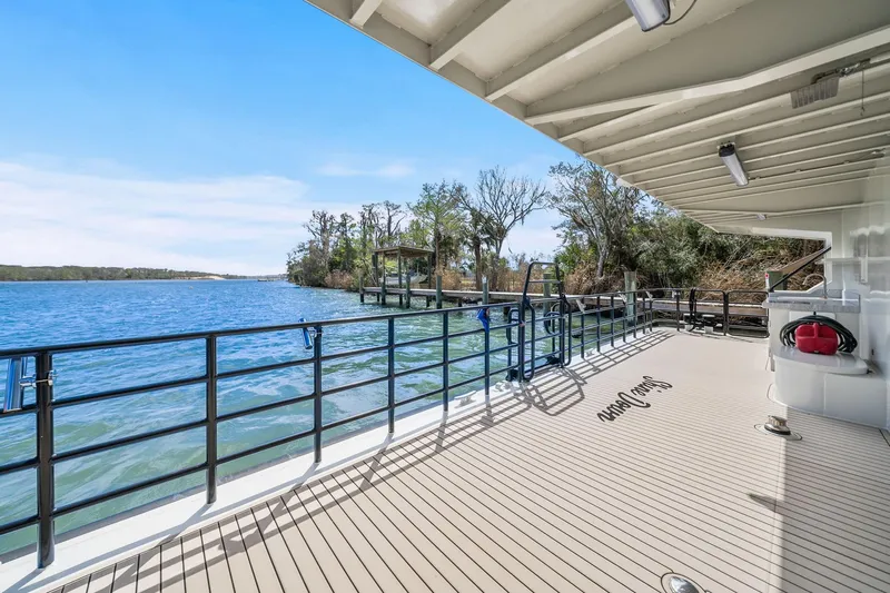 Shine Down Yacht Photos Pics Deck view of 2025 Breaux Brothers 120 GLV boat, overlooking serene waters and lush shoreline.