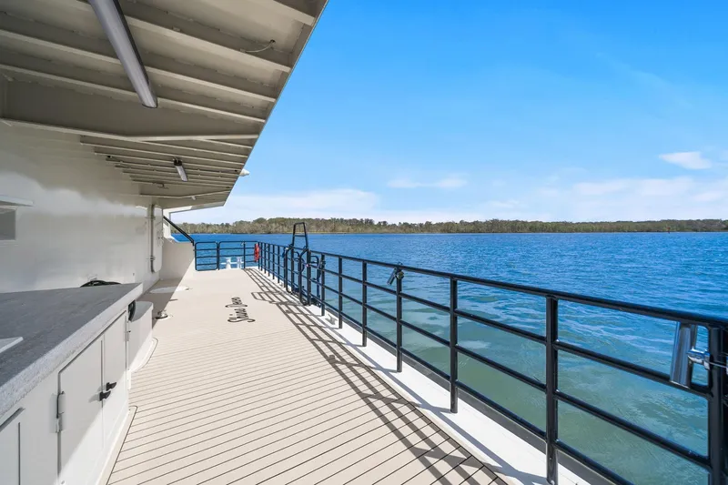 Shine Down Yacht Photos Pics Deck view of 2025 Breaux Brothers 120 GLV yacht on a serene lake.