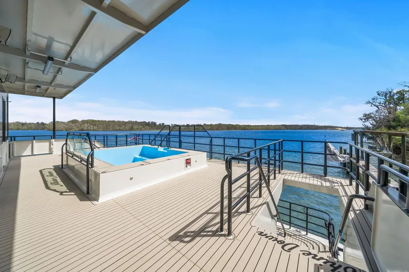 Shine Down Yacht Photos Pics Luxurious deck of 2025 Breaux Brothers 120 GLV yacht with pool and scenic water view.