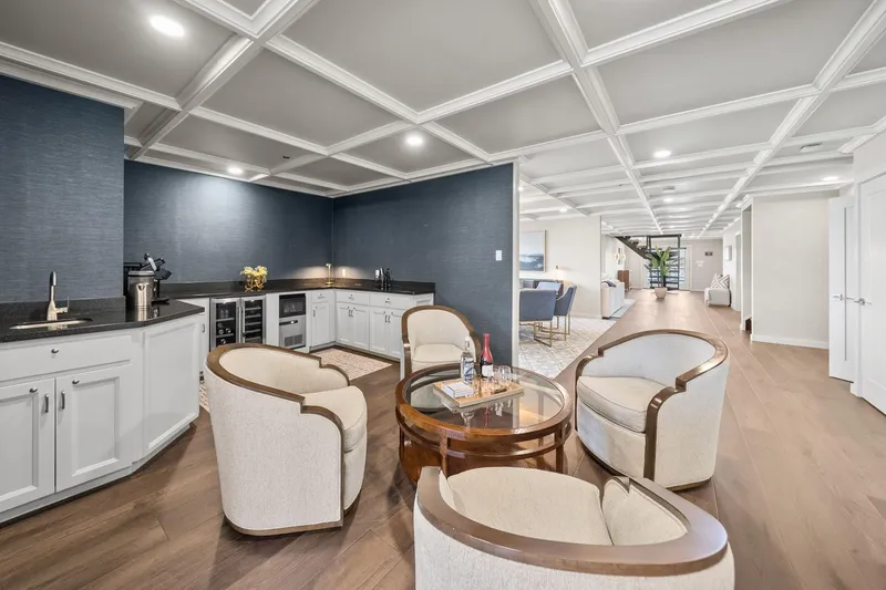 Shine Down Yacht Photos Pics Luxurious modern interior with elegant seating, coffered ceiling, and sleek kitchenette in a spacious room.