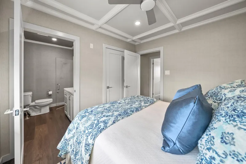 Shine Down Yacht Photos Pics Modern bedroom with blue bedding, ensuite bathroom, and coffered ceiling in Breaux Brothers 120 GLV, 2025.