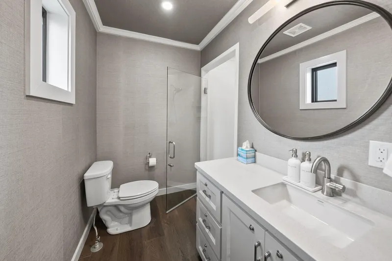 Shine Down Yacht Photos Pics Modern bathroom with glass shower, round mirror, and sleek vanity in a Breaux Brothers 120 GLV.