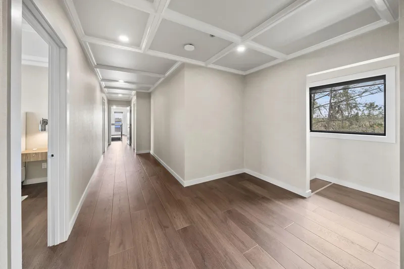 Shine Down Yacht Photos Pics Modern hallway with wooden flooring and coffered ceiling, featuring a side window view.